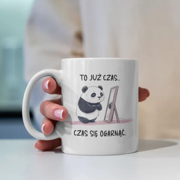 Zabawna urocza panda jako grafika na kubku. Stoi ona przed lustrem z napisem "To już czas... czas się ogarnąć".