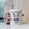 Grafika na kubku przedstawiająca pandę w stroju superbohatera z napisem "Moja supermoc? Kawa!"