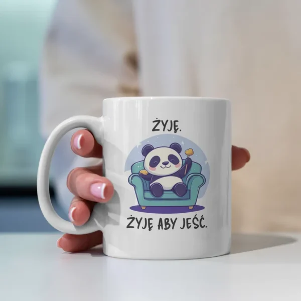 Uroczy kubek z pandą na fotelu z jedzonkiem i napisem "Żyję aby jeść"
