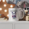 Grafika na kubku przedstawiająca pandę w stroju superbohatera z napisem "Moja supermoc? Kawa!"
